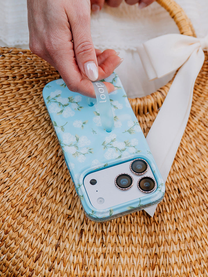 A woman holding a Hydrangeas Loopy Case. || feature-media