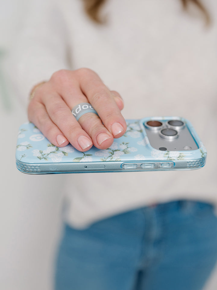 A woman holding a Hydrangeas Loopy Case. || feature-media
