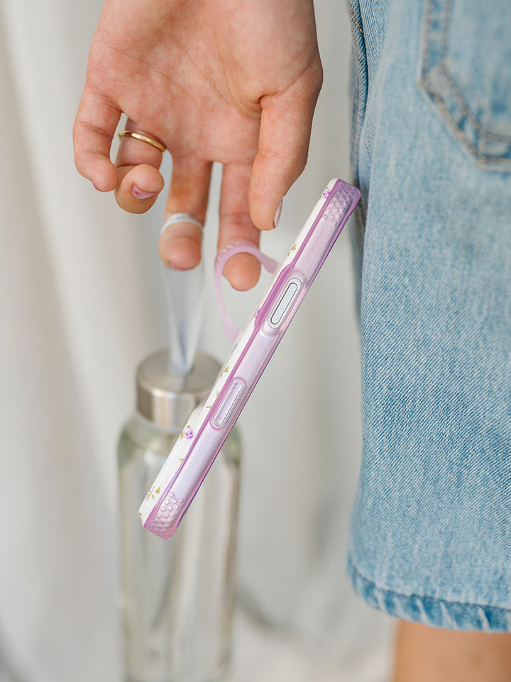 A woman holding a Lilac Fields Loopy Case. || feature-media