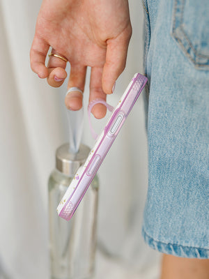 A woman holding a Lilac Fields Loopy Case. || feature-media