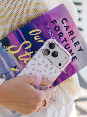 A woman holding a Lilac Fields Loopy Case. || feature-media