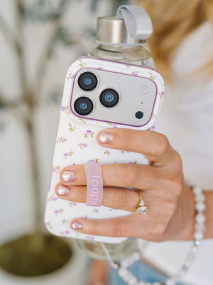 A woman holding a Lilac Fields Loopy Case. || feature-media