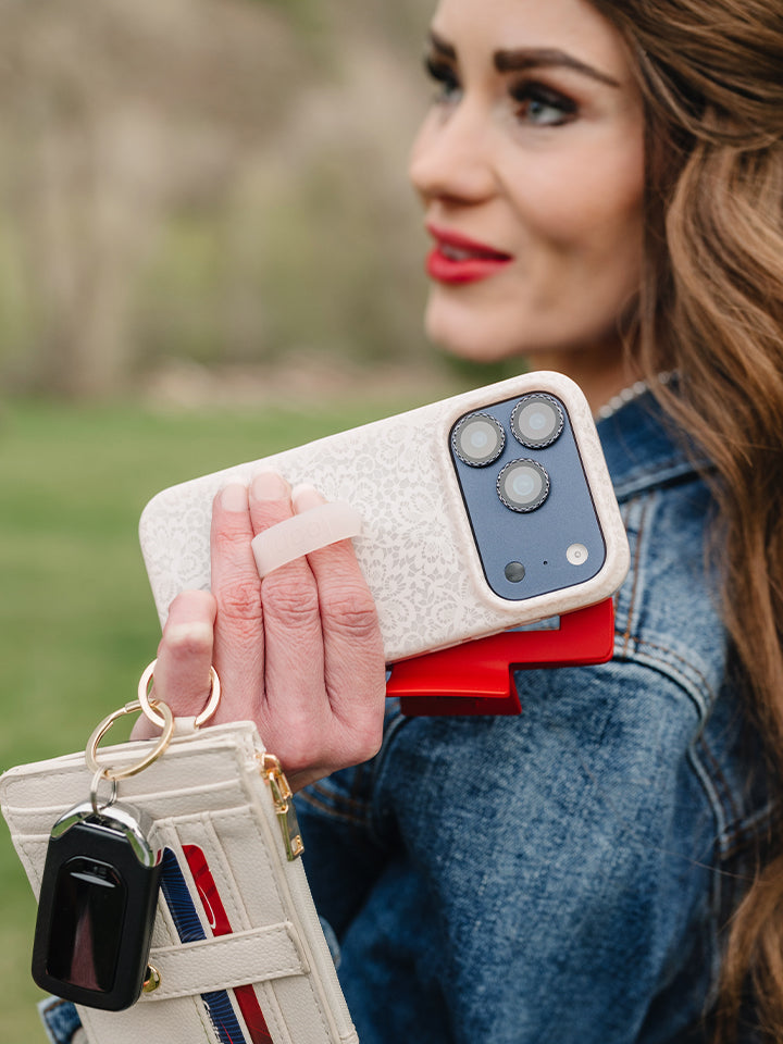 A woman holding a Lovely Lace Loopy Case. || feature-media