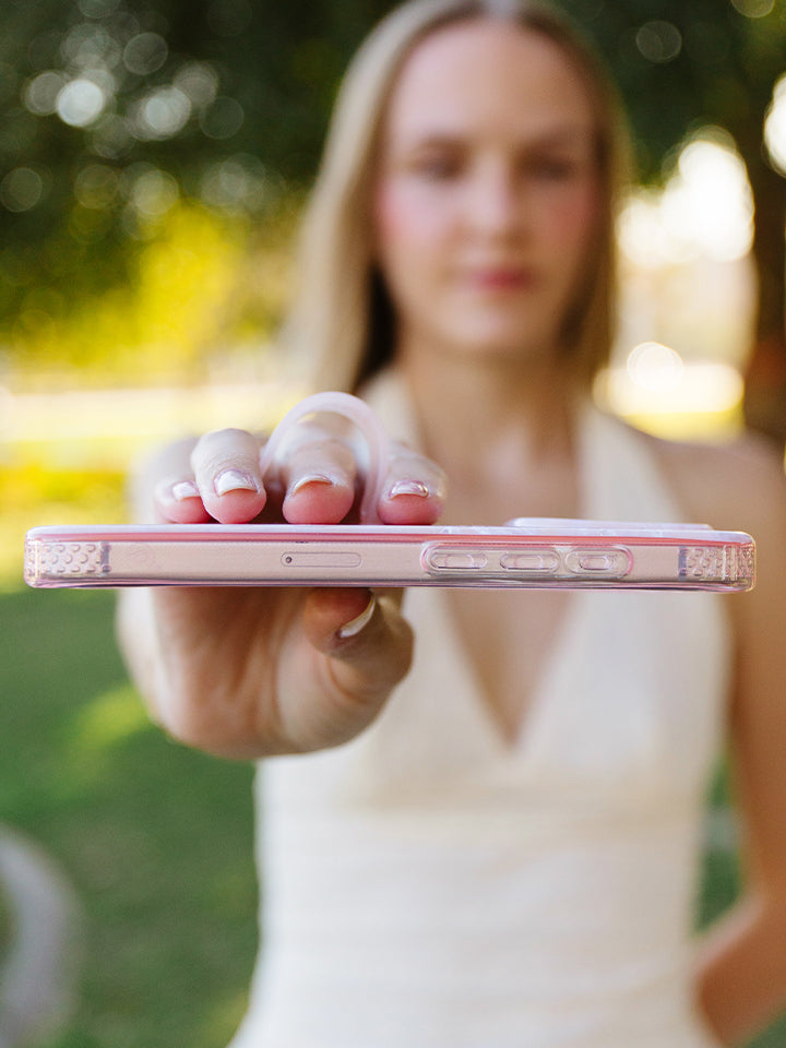 A woman holding a Blush Moonstone Loopy Case. || feature-media
