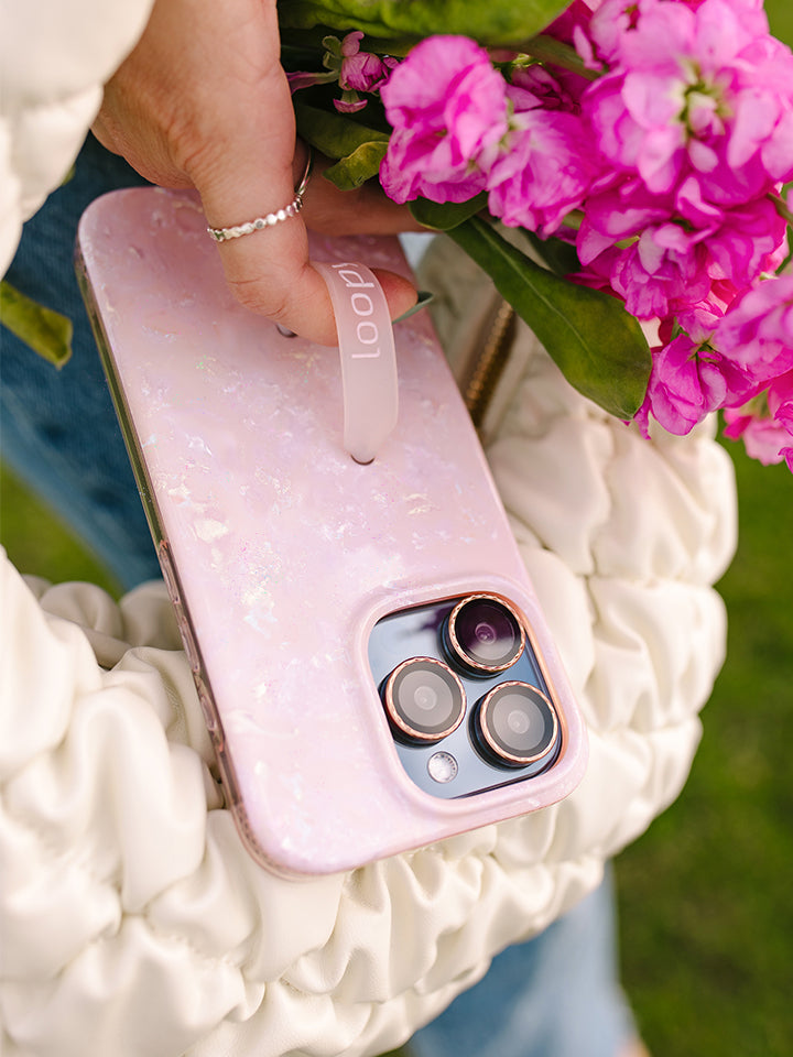 A woman holding a Blush Moonstone Loopy Case. || feature-media