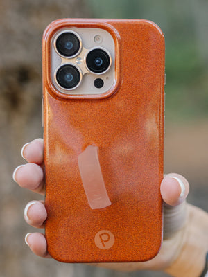 A woman holding an Orange Shimmer Loopy Case. || feature-media