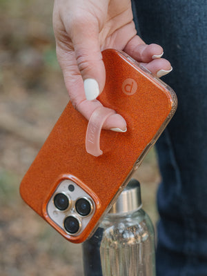 A woman holding an Orange Shimmer Loopy Case. || feature-media