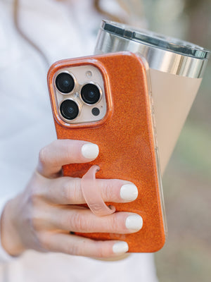 A woman holding an Orange Shimmer Loopy Case. || feature-media