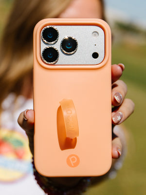 A woman holding a Peach Fizz Loopy Case. || feature-media