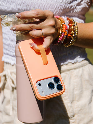 A woman holding a Peach Fizz Loopy Case. || feature-media