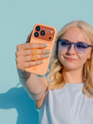 A woman holding a Peach Fizz Loopy Case. || feature-media