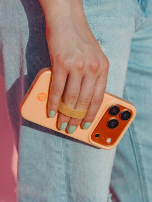 A woman holding a Peach Fizz Loopy Case. || feature-media