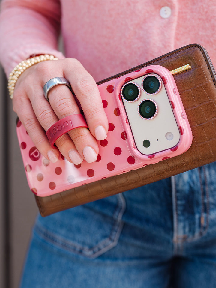 A woman holding a Raspberry Dots Loopy Case. || feature-media