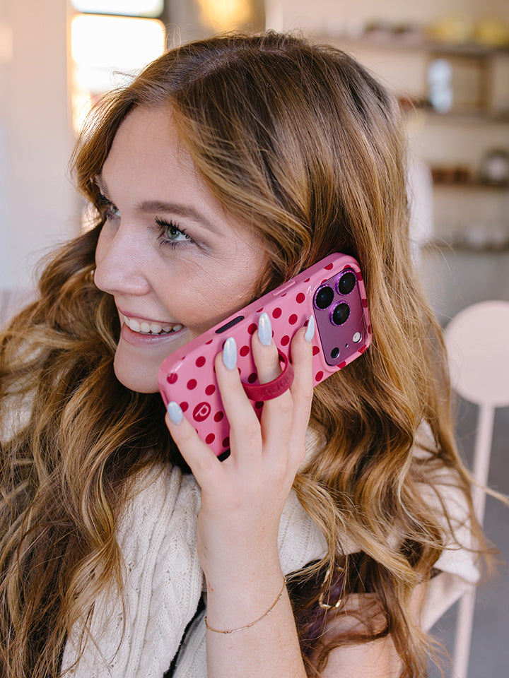 A woman talking on the phone while using a Raspberry Dots Loopy Case. || feature-media