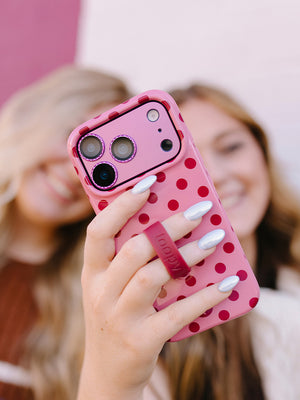 A woman holding a Raspberry Dots Loopy Case. || feature-media