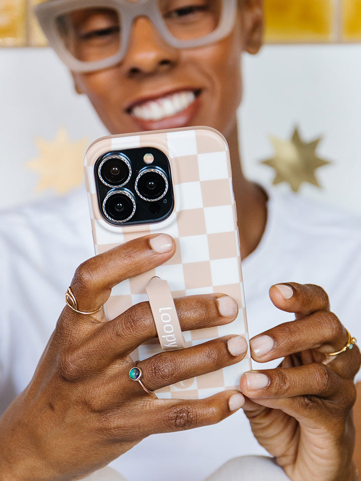 A woman holding a Sand Dollar Checkered Loopy Case. 