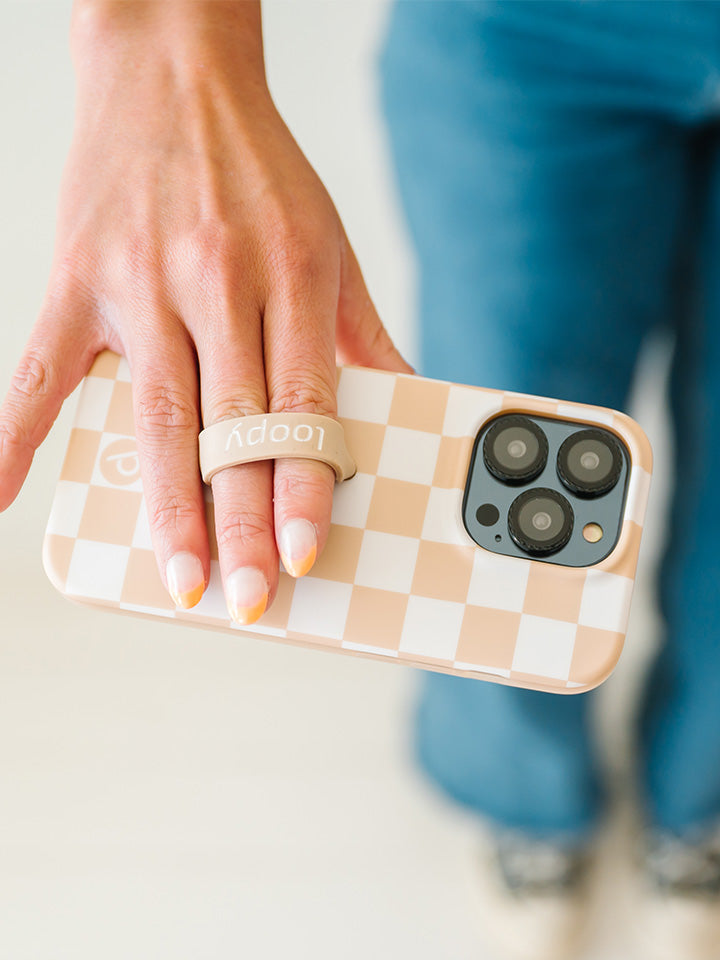 A woman holding a Sand Dollar Checkered Loopy Case. 
