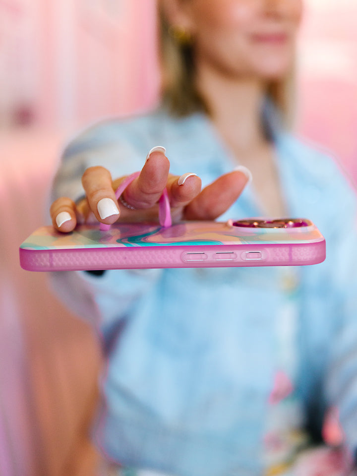 A woman holding a Sherbet Swirl Loopy Case. || feature-media