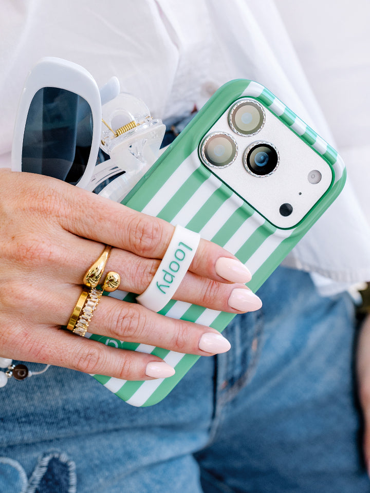 A woman holding a Spearmint Stripes Loopy Case. || feature-media