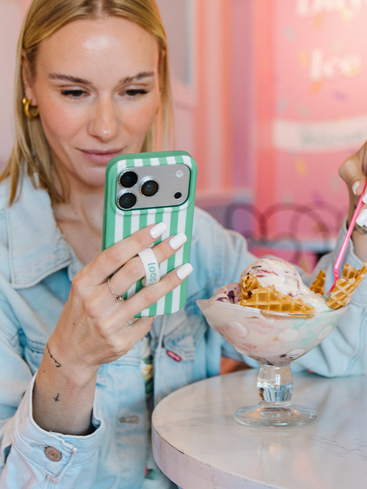 A woman holding a Spearmint Stripes Loopy Case. || feature-media