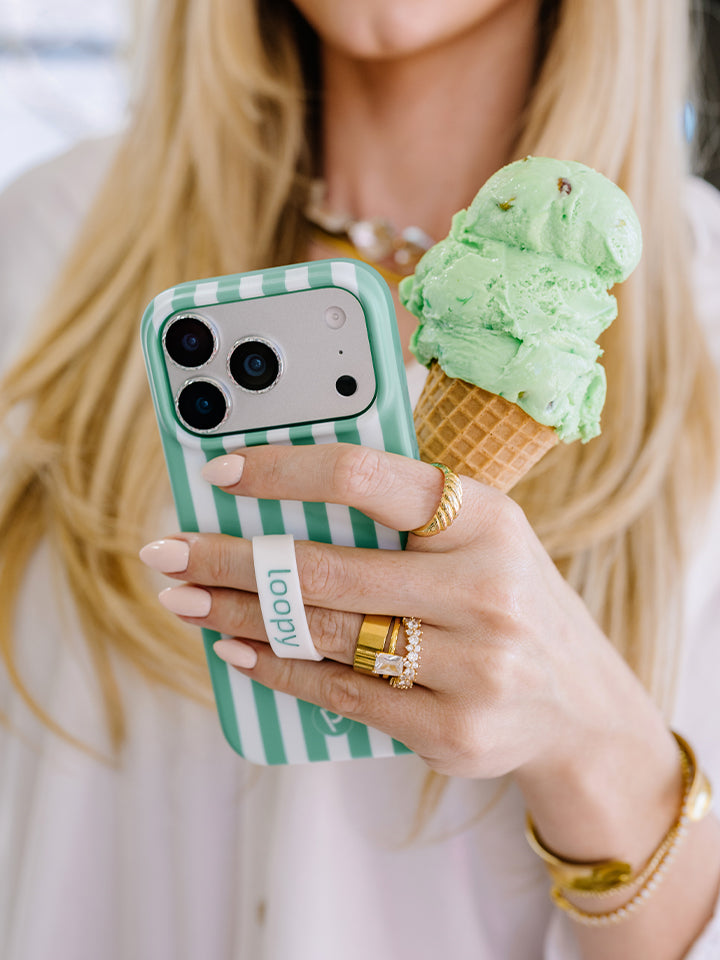 A woman holding a Spearmint Stripes Loopy Case. || feature-media