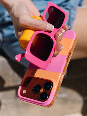 A woman holding a Sunset Stripes Loopy Case. || feature-media
