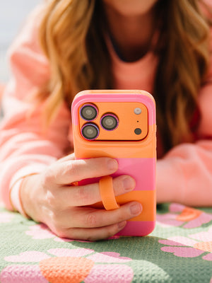 A woman holding a Sunset Stripes Loopy Case. || feature-media