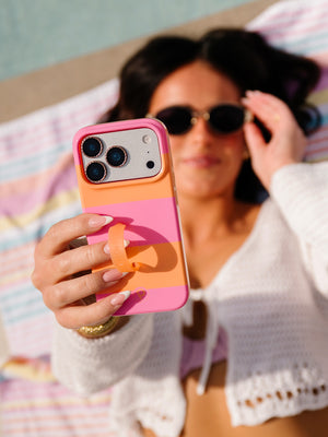 A woman holding a Sunset Stripes Loopy Case. || feature-media