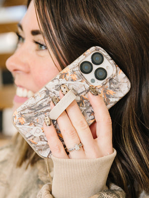 A woman talking on the phone while using a Tree Camo Loopy Case. || feature-media
