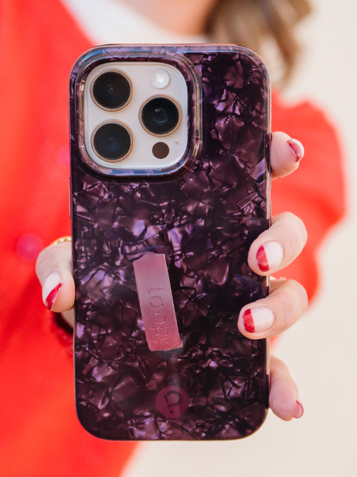 A woman holding a Wine Opal Shell Loopy Case. || feature-media
