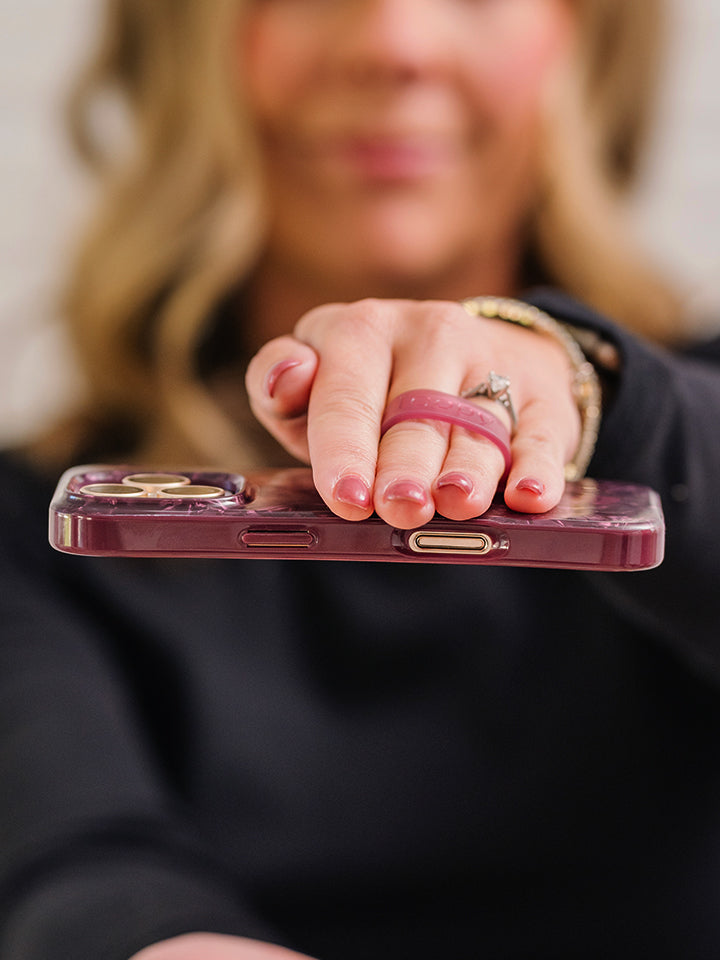 A woman holding a Wine Opal Shell Loopy Case. || feature-media
